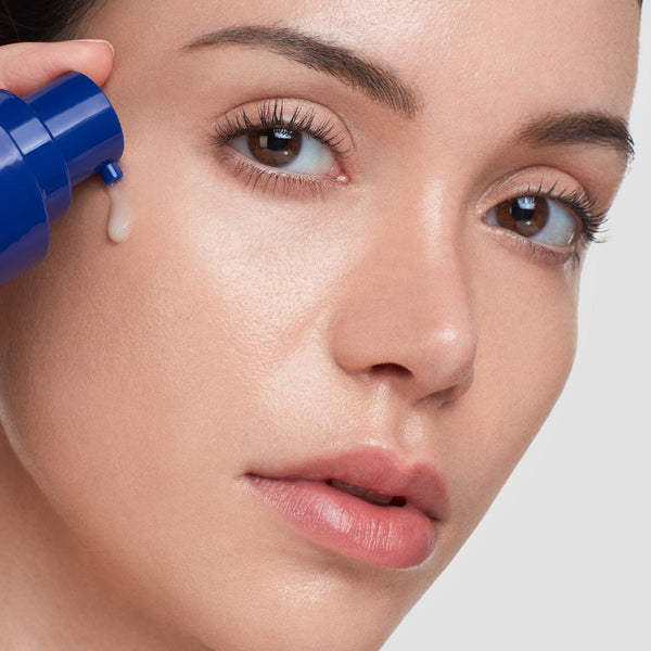 Close-up of a woman applying Power Serum | HydroPeptide skincare serum to her cheek, showcasing smooth, radiant skin and healthy beauty.