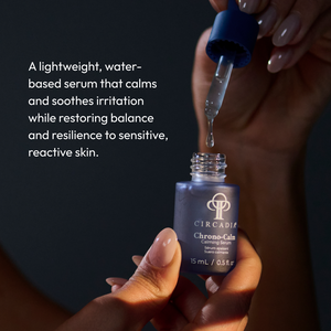 A person holding a small blue frosted glass bottle with a dropper dispensing a clear serum, featuring the product name Chrono-Calm | Circadia, described as a lightweight, water-based calming skincare serum for sensitive, reactive skin.