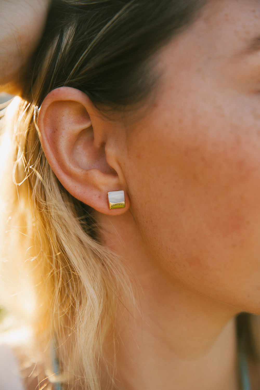 Close-up of elegant square-shaped stud earrings with gold dipped detailing over a soft pearl base, showcasing the Gold Dipped Pearl Studs | Meghan Bo Designs.