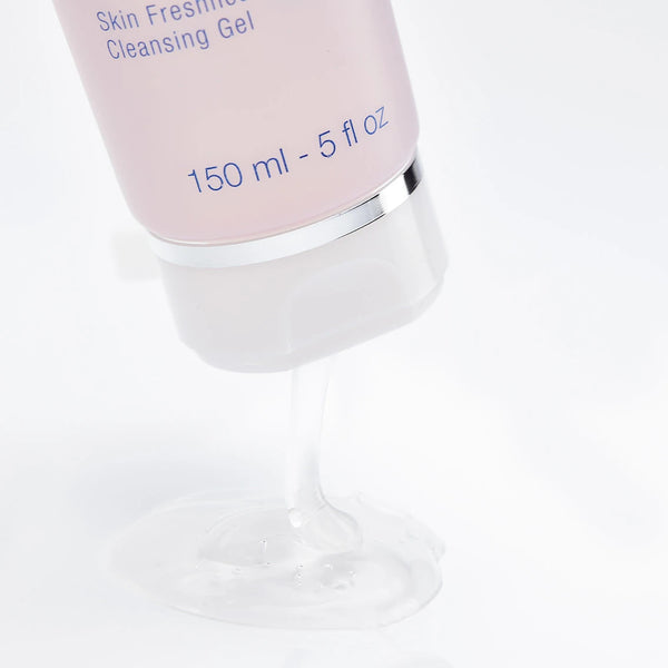Close-up of clear cleansing gel pouring from a pink tube, highlighting texture of Rosée Visage Skin Freshness Cleansing Gel | Phytomer for skincare and wellness.