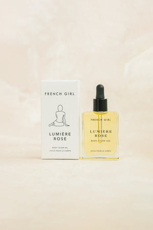 Lumière Body Glow Oil - Rose | French Girl in a clear glass bottle with black dropper beside its minimalist white packaging, highlighting skincare and body care wellness.