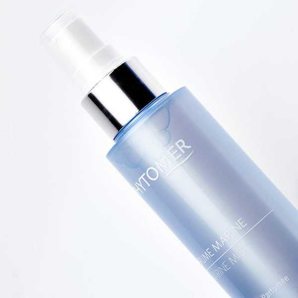 Close-up of a sleek blue spray bottle labeled Marine Mist | Phytomer with a silver pump, designed for skincare and body care wellness.