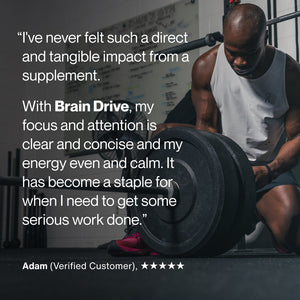 Athletic man in workout clothes preparing to lift weights in a gym alongside a testimonial highlighting Brain Drive’s benefits for focus, attention, and balanced energy.