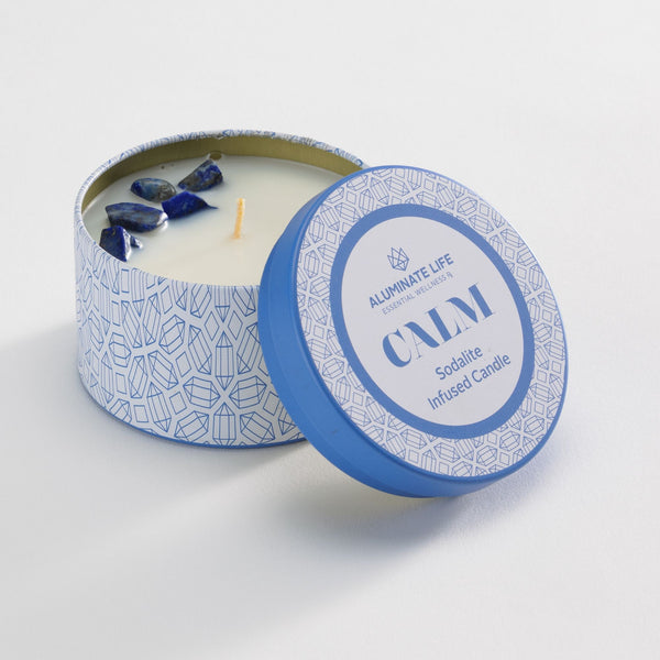 Calm Candle Tin 6 oz | Aluminate Life features a blue patterned tin with sodalite crystals embedded in a white candle, designed for wellness and relaxation.