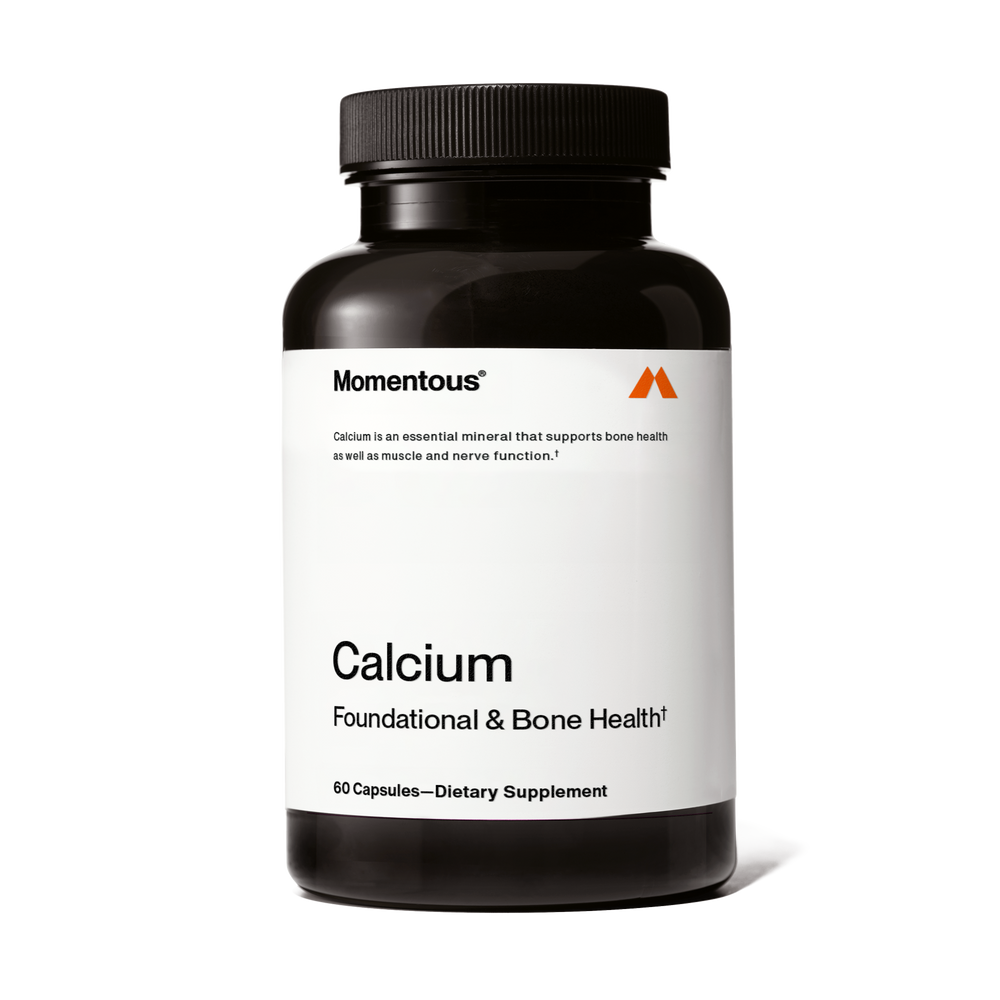 A black bottle of Calcium dietary supplement capsules with a white label highlighting its support for bone, muscle, and nerve health.