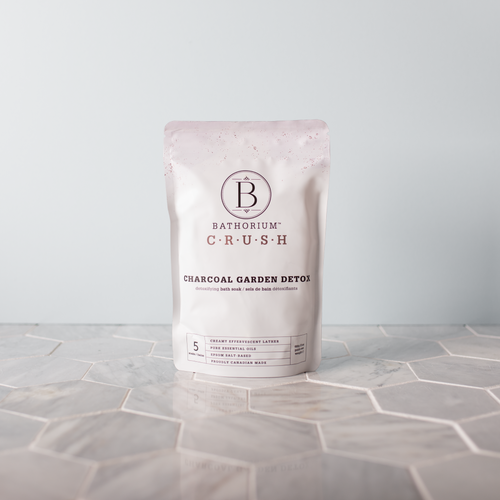 Packaging of Charcoal Garden Detox Crush | Bathorium bath soak, standing on a hexagonal tile surface with soft natural lighting, showcasing skincare and body care wellness product.