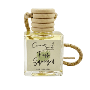 Square glass car diffuser with wooden top and natural rope for hanging, labeled Fresh Squeezed scent, Car Diffuser | CommonScents by Tayler E