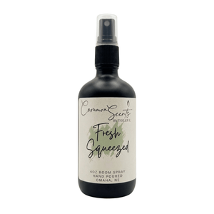 Black spray bottle with a white label reading "Fresh Squeezed," featuring a green watercolor accent, displaying the 4oz Luxury Room Spray | CommonScents by Tayler E brand.