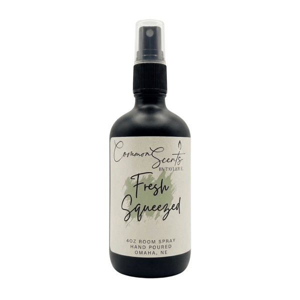 Black spray bottle with a white label reading "Fresh Squeezed," featuring a green watercolor accent, displaying the 4oz Luxury Room Spray | CommonScents by Tayler E brand.