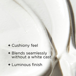 Close-up of creamy white moisturizer texture with text highlighting cushiony feel, seamless blending without white cast, and luminous finish for DAILY PREVENTION Ultra Defense Moisturizer SPF 50 | IMAGE Skincare.