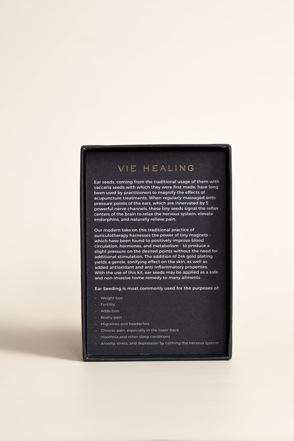 Back view of product packaging for Pain Conrol - 24K Gold Ear Seed | Vie Healing, featuring detailed text describing ear seed benefits and usage for wellness and pain relief.