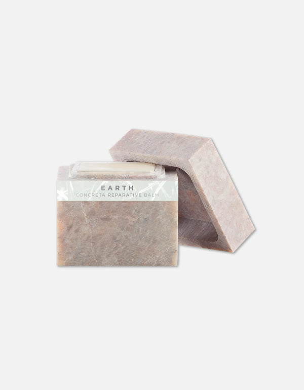 Two earth-toned solid bars of Concreta | Zents reparative balm against a light background, showcasing natural textured surface and minimalist packaging for skincare use.