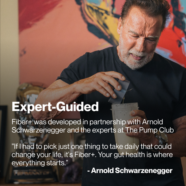 Arnold Schwarzenegger preparing a wellness supplement shake with Fiber+ 10-Travel Packs, promoting gut health and daily wellness support.