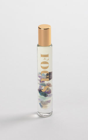 Focus Rollerball | Aluminate Life with clear glass bottle, gold cap, containing a blend of colorful stones inside, designed for skincare and wellness use.