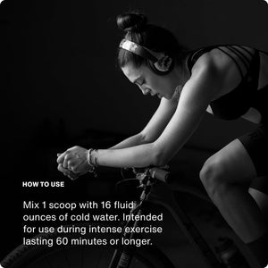 Woman wearing headphones intensely cycling indoors with instructions on how to use Fuel for hydration and endurance during long exercise sessions