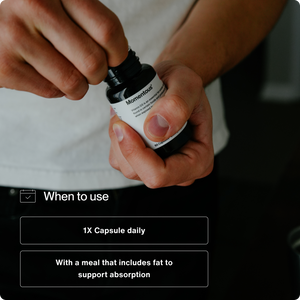 Person opening a bottle of supplements with text instructions for Vitamin D3 5000 IU recommending one capsule daily taken with a meal that includes fat to support absorption.