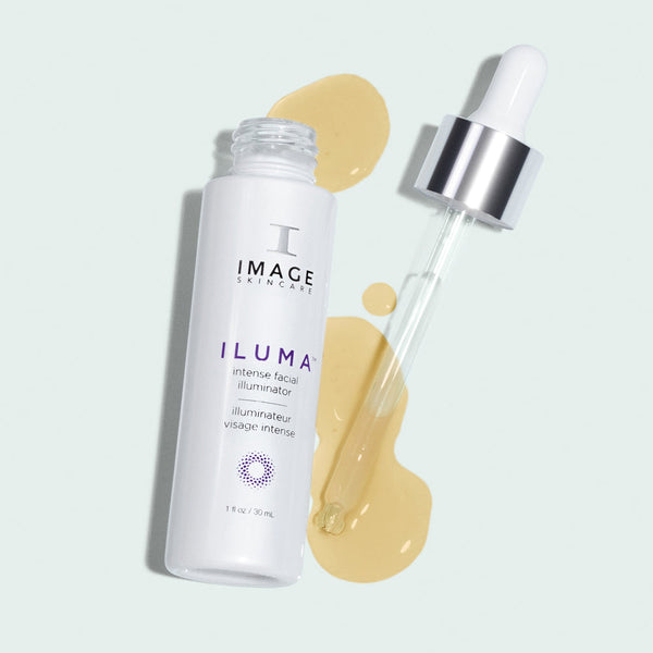 ILUMA intense facial illuminator | IMAGE Skincare product bottle with dropper and spilled golden serum on a light background, representing skincare and wellness.