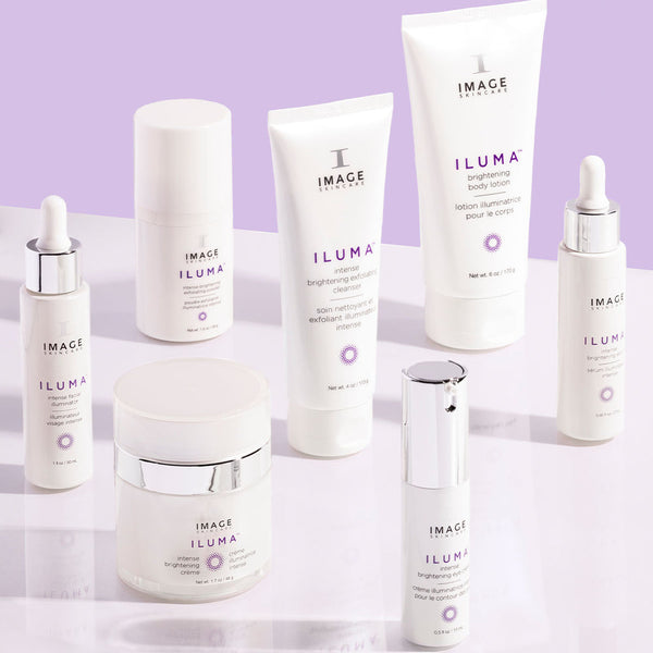 Assorted skincare products from IMAGE Skincare’s ILUMA line displayed on a lavender background, featuring the ILUMA intense facial illuminator | IMAGE Skincare designed for radiant skin.
