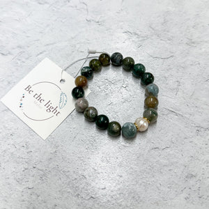 Jasper Luxe Bracelet | Be the Light featuring polished multi-colored natural stone beads with a small gold accent bead, displayed on a light textured surface with a branded tag.