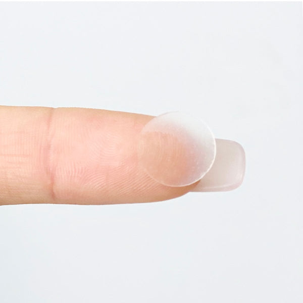 A translucent acne treatment dot resting on the fingertip, designed for targeted skincare use with the Popspot Spot Treatment - Acne & Pimple Remover Dot (48 Pack) | Popmask.