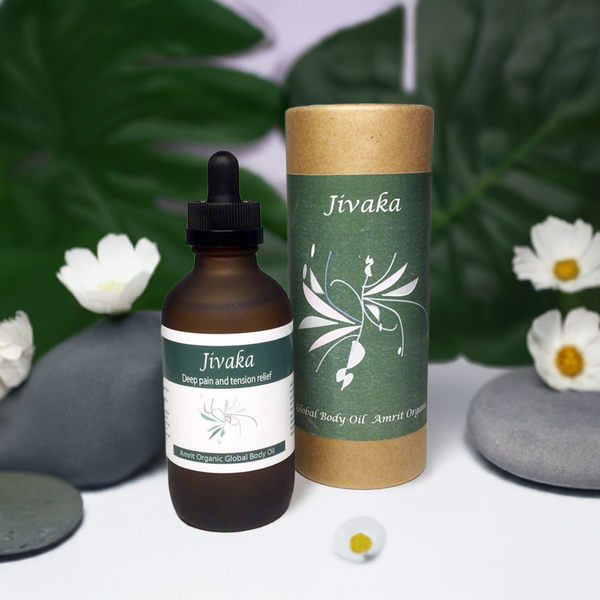 Jivaka Body Oil | Red Cherry Group in a brown glass bottle with dropper alongside green and brown cylindrical packaging, surrounded by smooth stones and white flowers, promoting skincare and wellness.