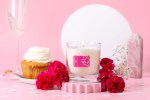 I Choose Bliss Candle | Aluminate Life displayed on a pink label in a clear glass candle holder surrounded by red flowers, a vanilla cupcake, and soft pink decor for a calming wellness setting.