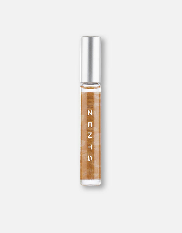Clear glass roll-on vial with light amber liquid and silver cap, featuring the text ZENTS, representing Attar Roll-on Scent | Zents for body care and wellness.