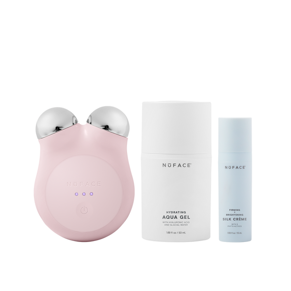 MINI+ Starter Kit | NuFACE featuring a pink handheld microcurrent device with two silver spheres, hydrating aqua gel, and firming brightening silk crème for skincare and wellness.