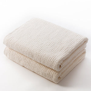 Two neatly folded natural-colored towels made of soft textured fabric, showcasing the Hotel Collection Organic Cotton | TOWL for a luxurious spa-like experience.