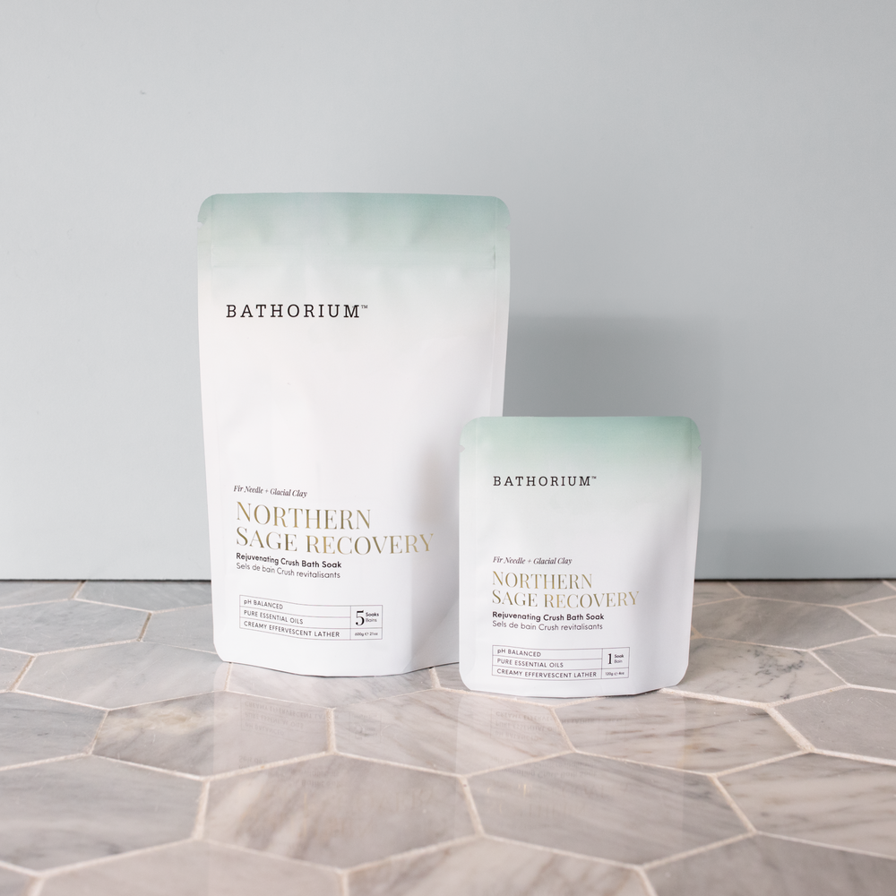 Northern Sage Recovery Crush | Bathorium pouches displayed on a marble surface, showing the Northern Sage Recovery bath soak packaging in two sizes