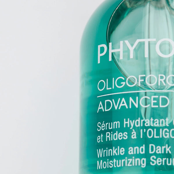 Close-up of a green bottle of Oligoforce Advanced Wrinkle & Dark Spot Correction Moisturizing Serum with Oligomer | Phytomer, highlighting skincare product details.