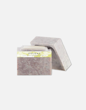 Two bars of Concreta | Zents reparative balm in muted natural tones positioned against a clean white background, highlighting their textured surfaces and packaging design.