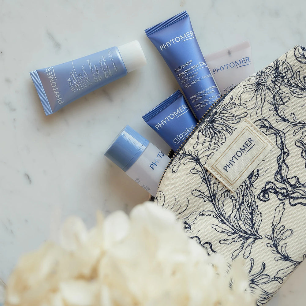Seaside Moisturizing Starter Kit | Phytomer featuring six skincare products in blue and white packaging with a patterned toiletry bag, ideal for moisturizing and body care.