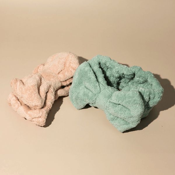 Two soft textured spa headbands in pastel peach and green colors displayed on a beige surface, designed for skincare and wellness use, Luxe Spa Headbands | Lucky Owl.