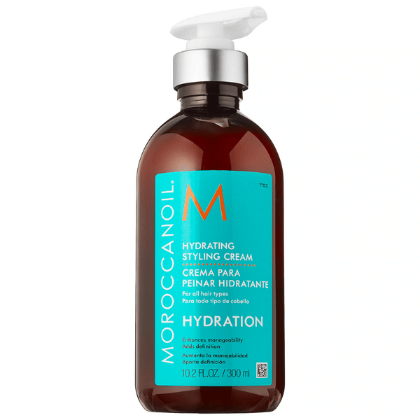 Bottle of Hydrating Styling Cream | Moroccanoil with pump dispenser, featuring turquoise label and orange accents, designed for enhancing hair hydration and manageability.