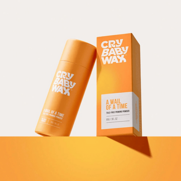 Bright orange packaging of A Wail of a Time Priming Powder | Crybaby Wax with bold white branding against a minimal light background for skincare and beauty wellness.