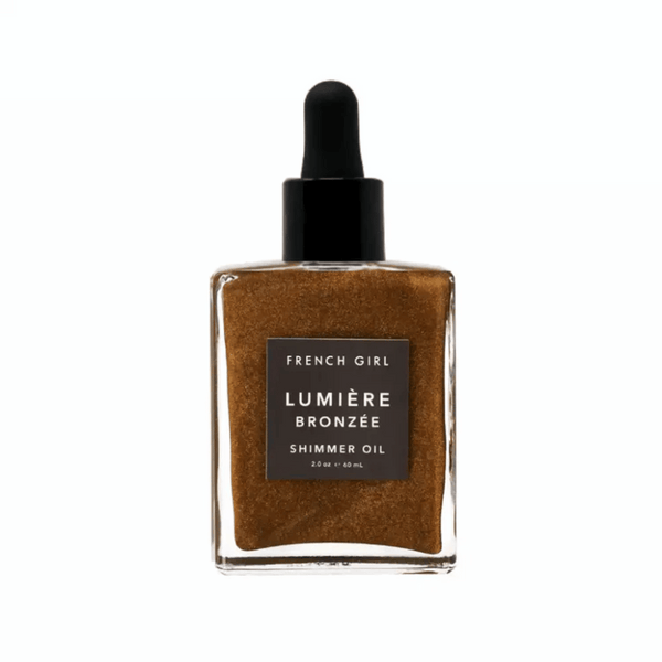 Glass bottle of Bronzée Shimmer Oil| French Girl with black dropper cap, containing bronze-colored shimmering body oil for radiant skincare and body care.