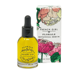 Glass dropper bottle of Florale Botanical Serum | French Girl with bright yellow liquid next to floral-designed product box featuring pink, cream, and green flowers.
