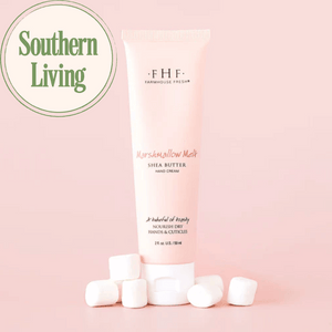 Tube of Marshmallow Melt Hand Cream | Farmhouse Fresh with shea butter surrounded by marshmallows on a soft pink background next to a Southern Living logo, highlighting skincare and body care.