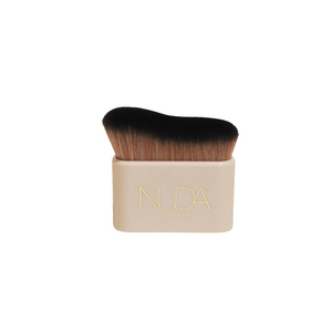 Blending Brush | NUDA with dense, soft bristles and a compact beige handle featuring gold embossed branding, designed for smooth makeup application and skincare blending.