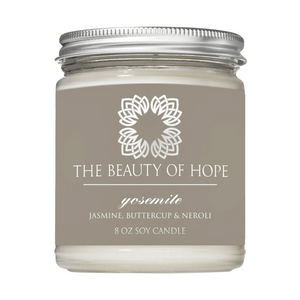 Yosemite 8oz Candle | The Beauty of Hope featuring a glass jar with a metal lid, labeled with jasmine, buttercup, and neroli scent for a calming and uplifting ambiance.