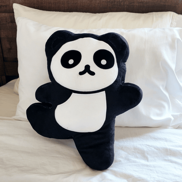 Soft black and white panda plush toy with simple facial features sitting on a white pillow, named Yogi Panda Plushie | Lucky Owl.