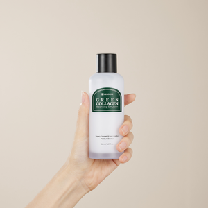 Hand holding a frosted bottle of Green Collagen Balancing Emulsion | Leaders skincare product with a black cap against a neutral background.