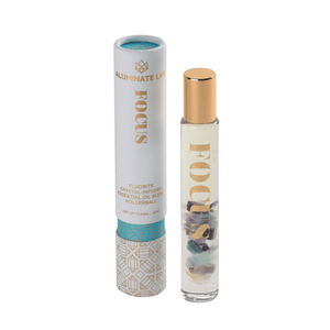 Focus Rollerball | Aluminate Life with fluorite crystal-infused essential oil blend in a clear glass rollerball bottle with gold cap and decorative white and gold packaging.