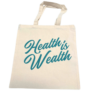 Beige fabric tote bag with teal script text reading "Health is Wealth" featured on the Health is Wealth Tote | Lucky Owl, ideal for carrying wellness supplements and body care products.