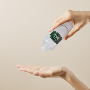 A person dispensing Green Collagen Synergy Toner | Leaders liquid onto their open palm against a neutral background.