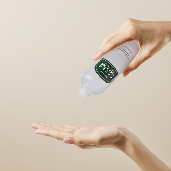A person dispensing Green Collagen Synergy Toner | Leaders liquid onto their open palm against a neutral background.