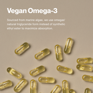 Close-up of clear golden capsules on a beige background highlighting natural omega-3 sourced from marine algae for The Momentous Three - Vegan wellness supplements.