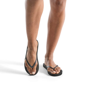 Close-up of a person wearing black Slimz Core Sandals | Feelgoodz, showcasing the slim, comfortable design ideal for casual wear and wellness-focused lifestyle.