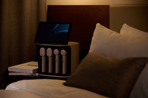 MediSpa Pro | Ceragem wellness device with handheld recovery tools and touchscreen display on bedside table in a cozy bedroom setting.